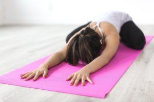 Donna fa esercizi su un tappetino yoga: migliori tappetini yoga