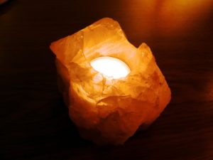Lampada di sale con lume di candela acceso al suo interno