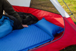 materassino da campeggio blu in una tenda rossa