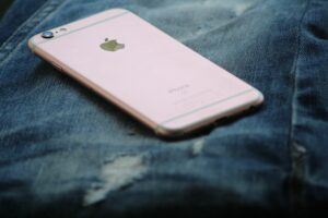 iPhone rosa appoggiato su dei jeans